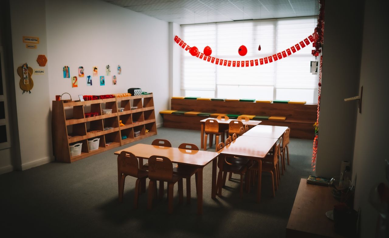 services-01 Inviting kindergarten classroom with tables, chairs, and colorful decorations, fostering a welcoming learning environment.