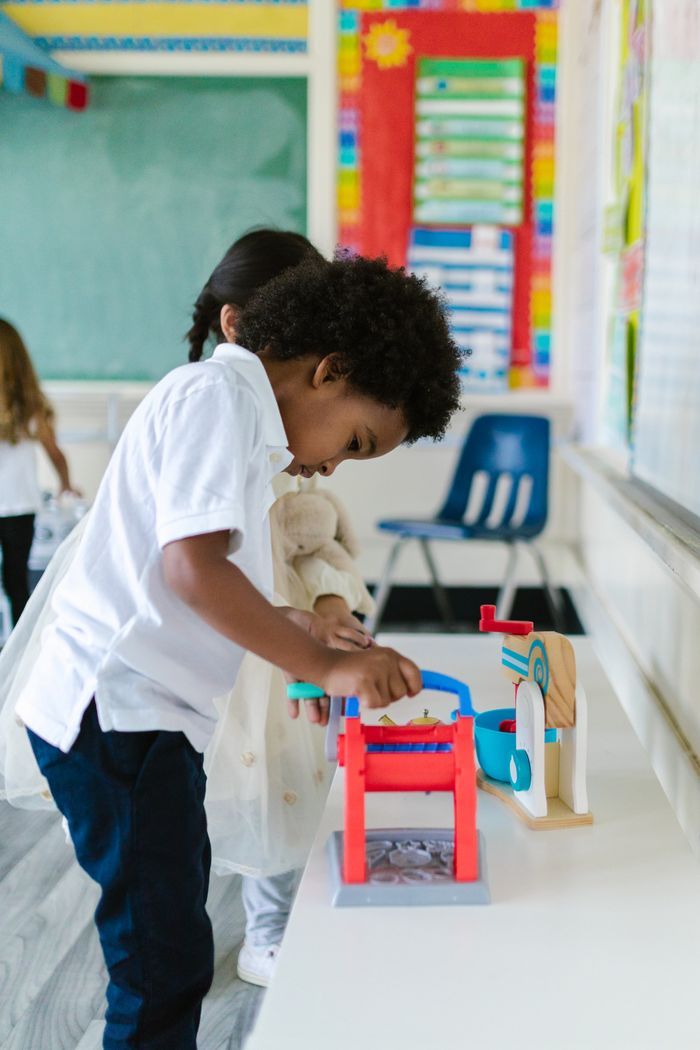 services-04 Young children playing with educational toys in a vibrant classroom setting.